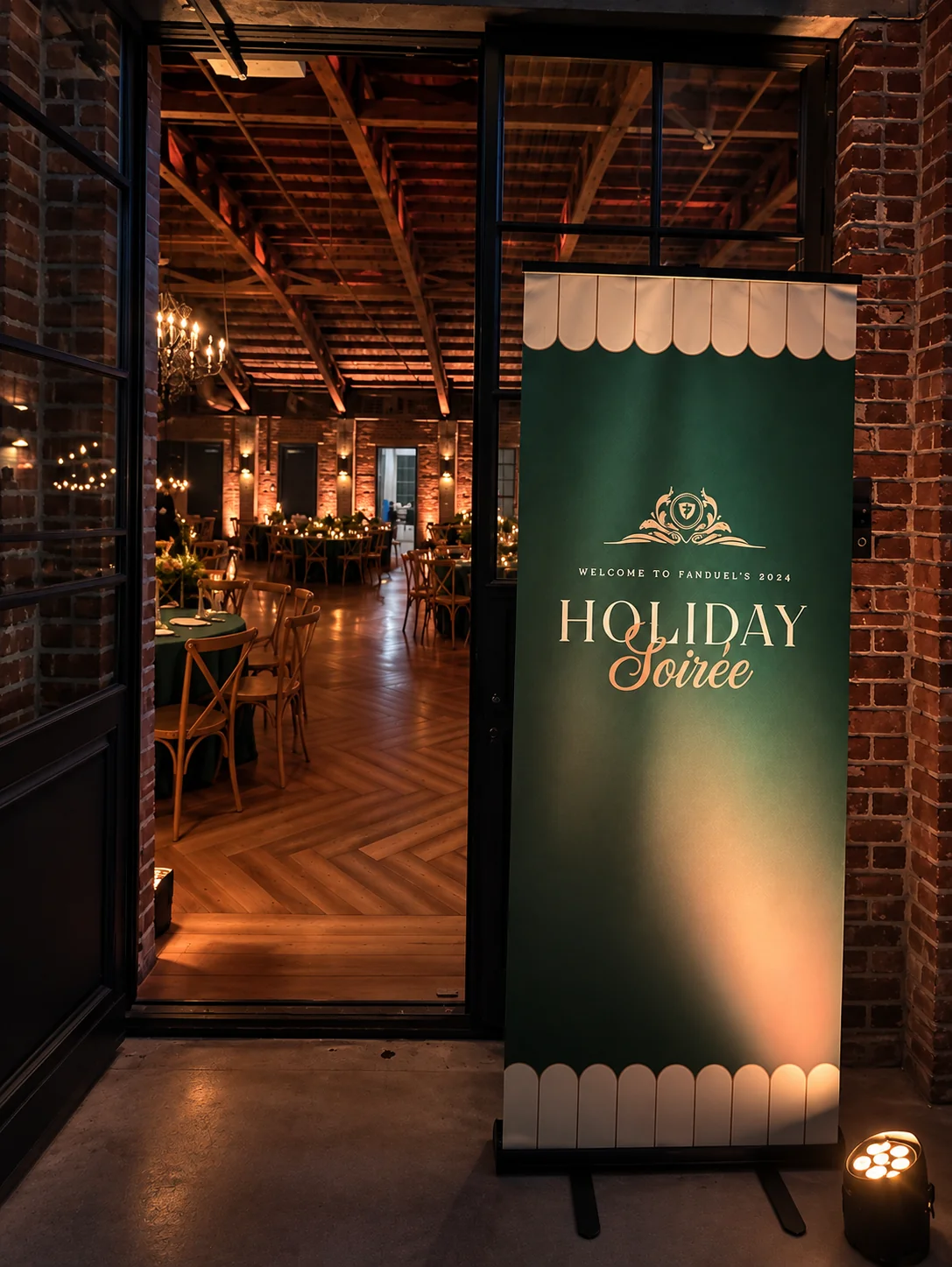 FanDuel 2024 Holiday Soirée welcome signage at the entrance to a warmly lit event venue